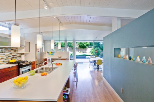 On a light background of the kitchen, the blue wall serves as a decorative accent