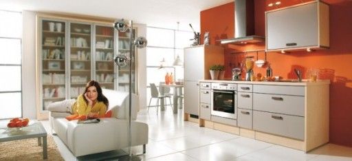 La pared naranja brillante está diseñada para servir como un acento en el interior de este estudio de cocina