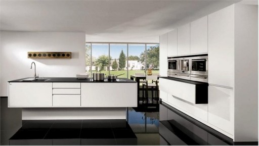 Valkoinen keittiö, jossa on musta pöytälevy ja lattia on kaunis, mutta tarkka puhtauden suhteen