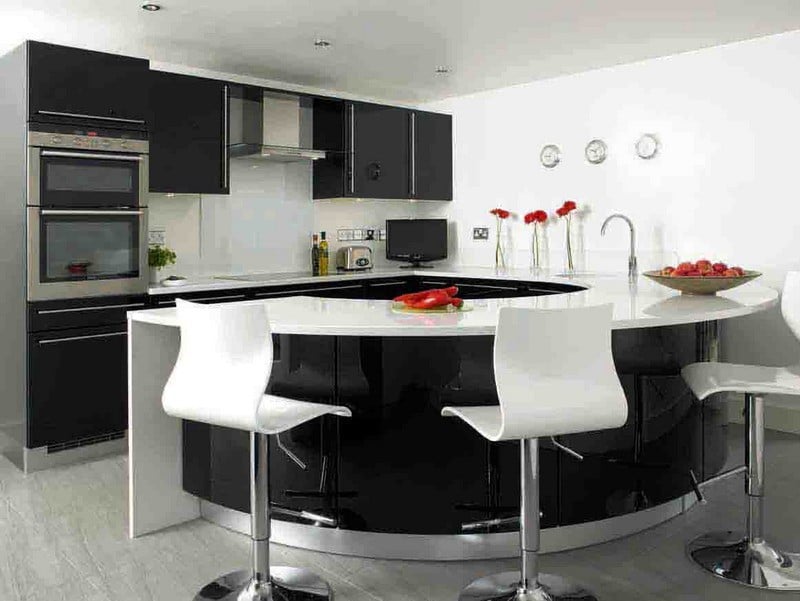 Di dapur hitam dan putih, sebuah bar dengan warna kontras menjadi elemen penting interior