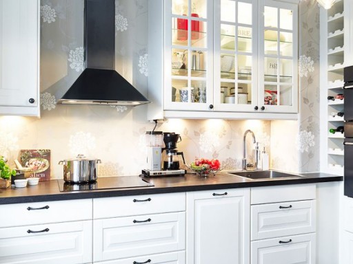 The snow-white background of the kitchen warms the soft lighting of the work surface and the hanging cabinet