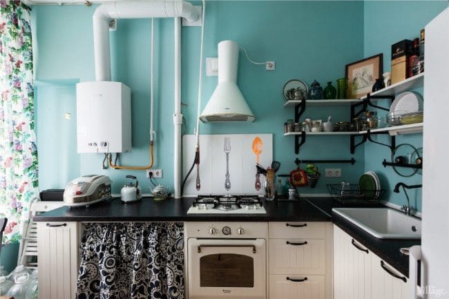 Bijela grijač vode i bijela napa u unutrašnjosti plave kuhinje u retro stilu