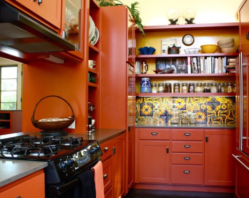 Den spanska stilen, med ljusa färger, förutsägbart fokuserad på den rika orangen i det inre av detta kök